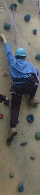 A scout climbing an artificial climbing wall.